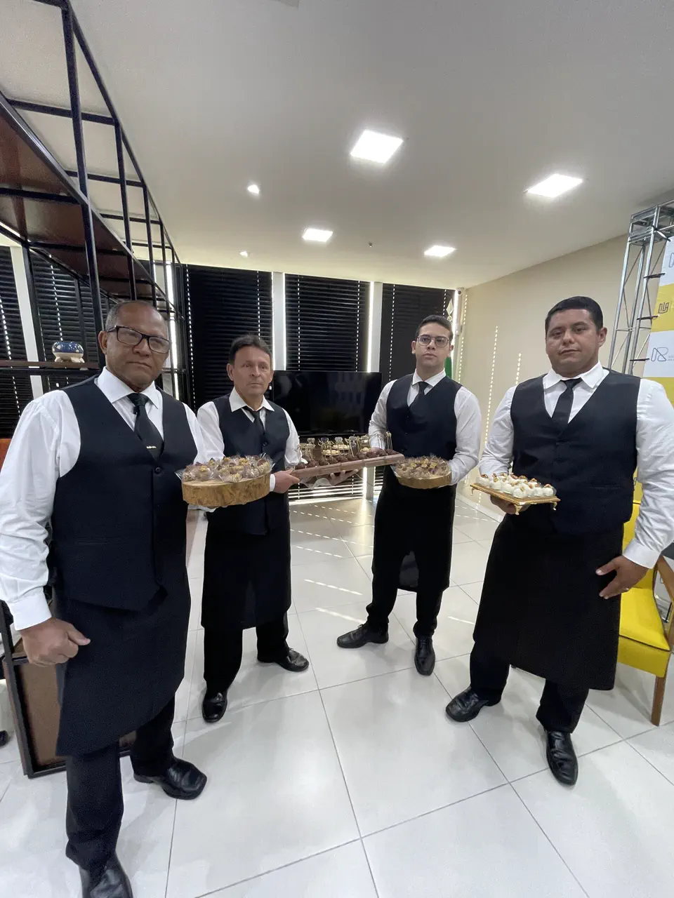 Garçons uniformizados do Dias de Festas servindo canapés